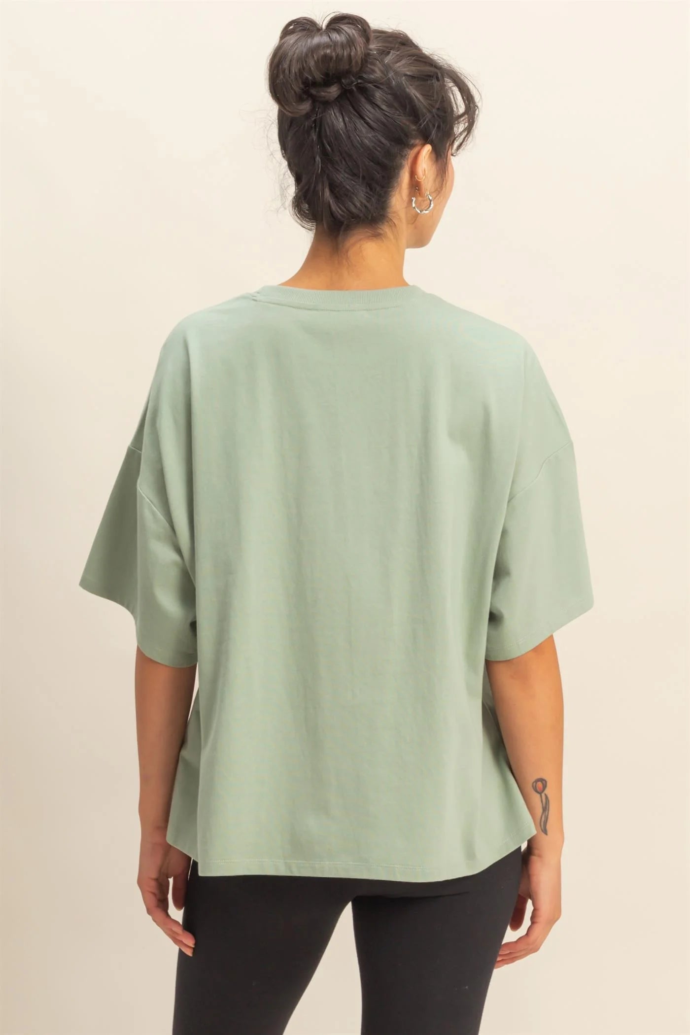 Person wearing a light green t-shirt on a beige background